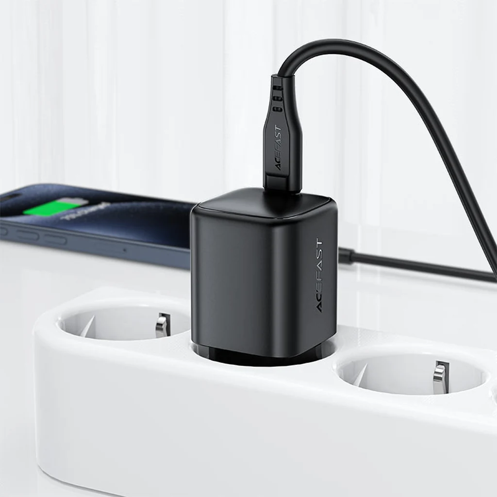 Acefast A134 67W GaN charger plugged into a power strip charging a smartphone with a USB-C cable