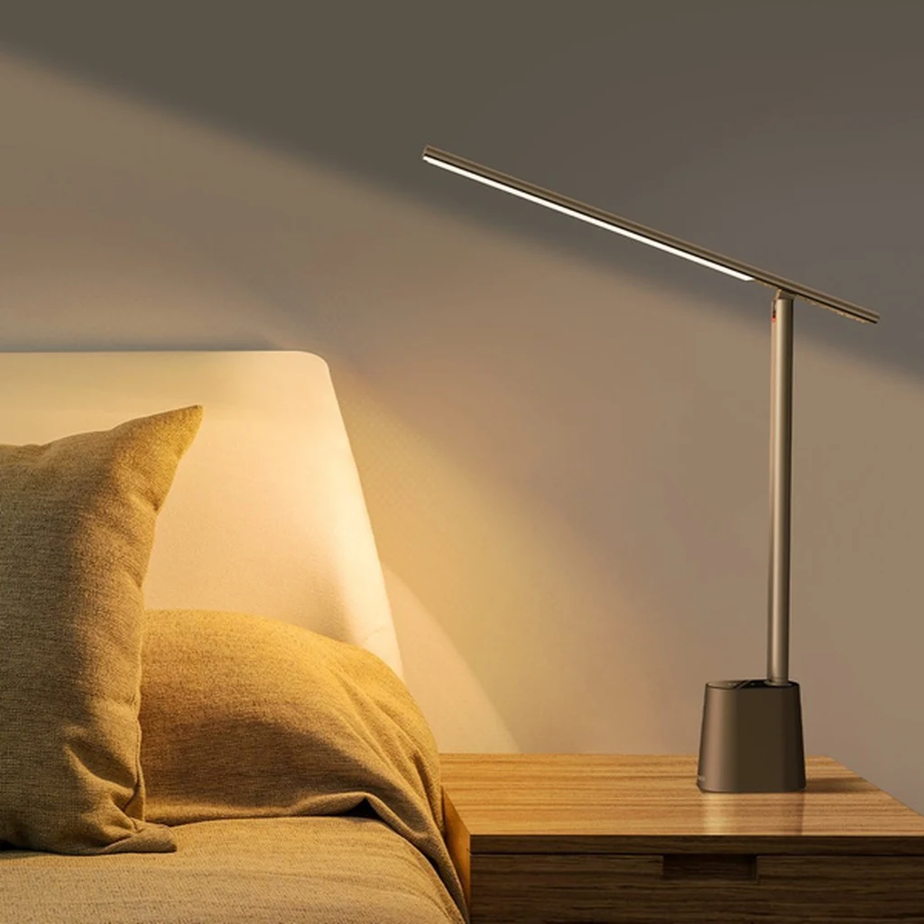 Baseus Smart Eye grey lamp switched on over a bedside table with warm ambient light