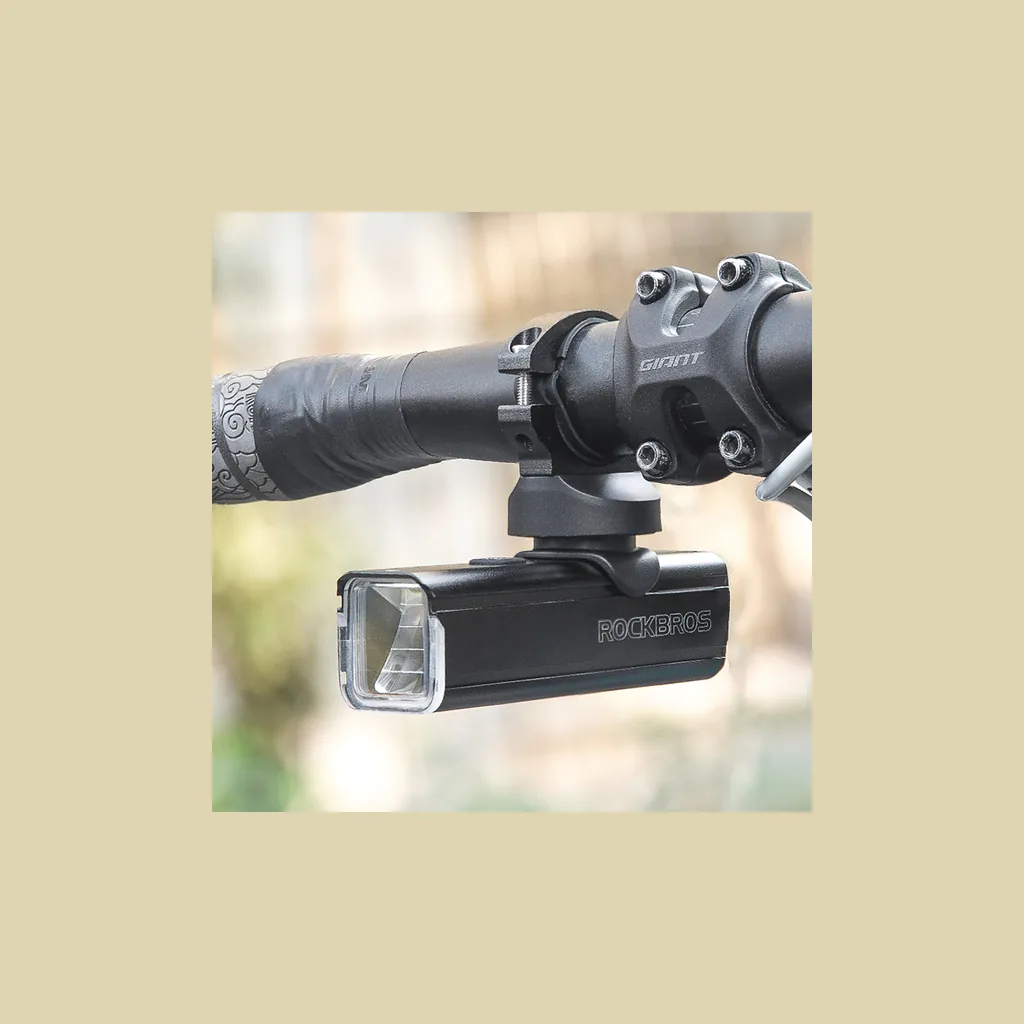 Luz ROCKBROS RHL1000 montada en posición invertida bajo un soporte adelantado de ciclocomputador