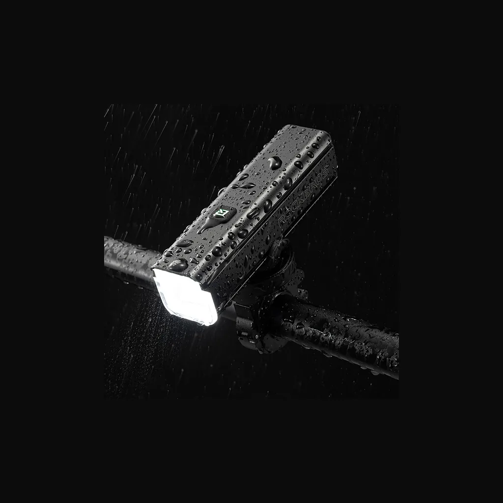 Luz ROCKBROS RHL1000 encendida bajo la lluvia demostrando su resistencia al agua